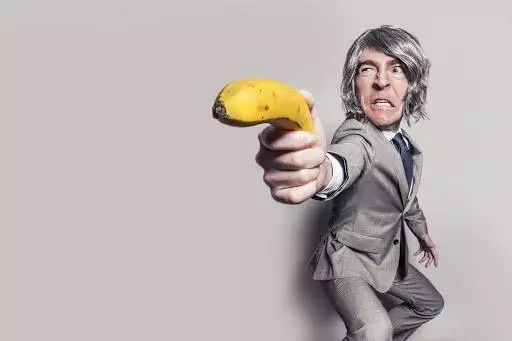 Guy in grey suit holding banana